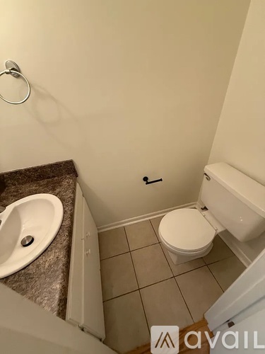 A small bathroom with a toilet, sink and shower.