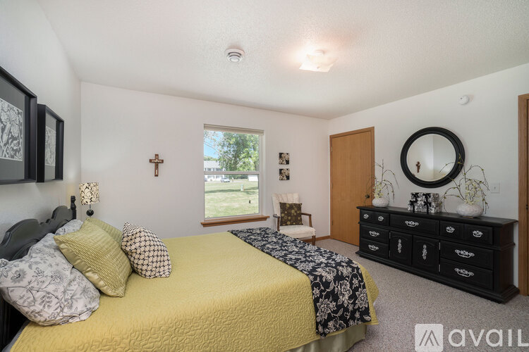 A bedroom with a bed, dresser, and mirror.