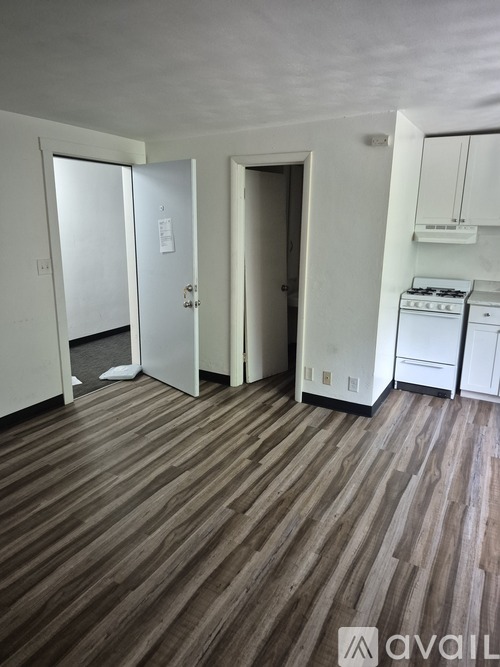 A room with a wood floor and a washer and dryer in it.