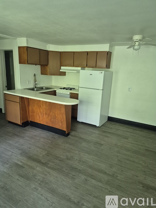 A kitchen with wooden cabinets and a white refrigerator.