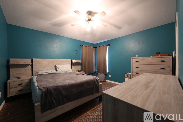 A bedroom with two beds and a ceiling fan.