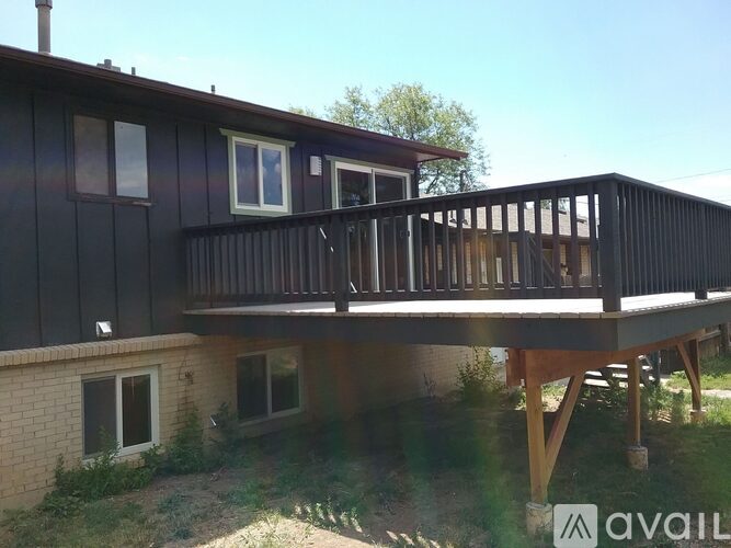 A house with a balcony and a brick foundation.