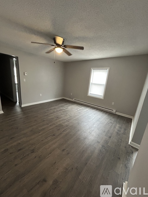 A room with a ceiling fan and a window.