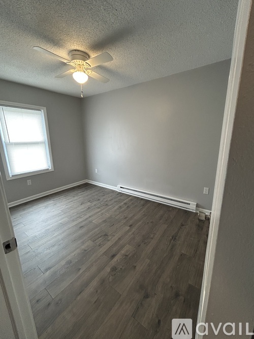 A room with a ceiling fan and a window.