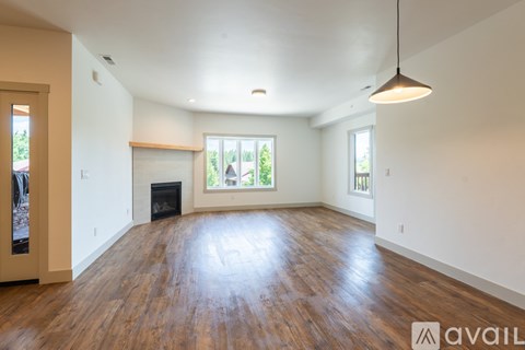 A spacious living room with hardwood floors and a fireplace.