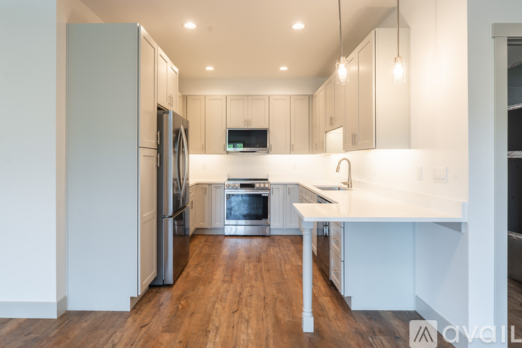 A kitchen with a refrigerator, oven, and sink.