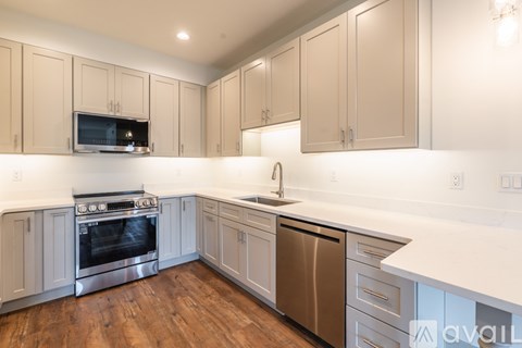 A kitchen with wooden floors and white countertops.