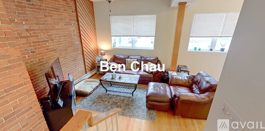 A living room with a brick wall and a leather sofa.