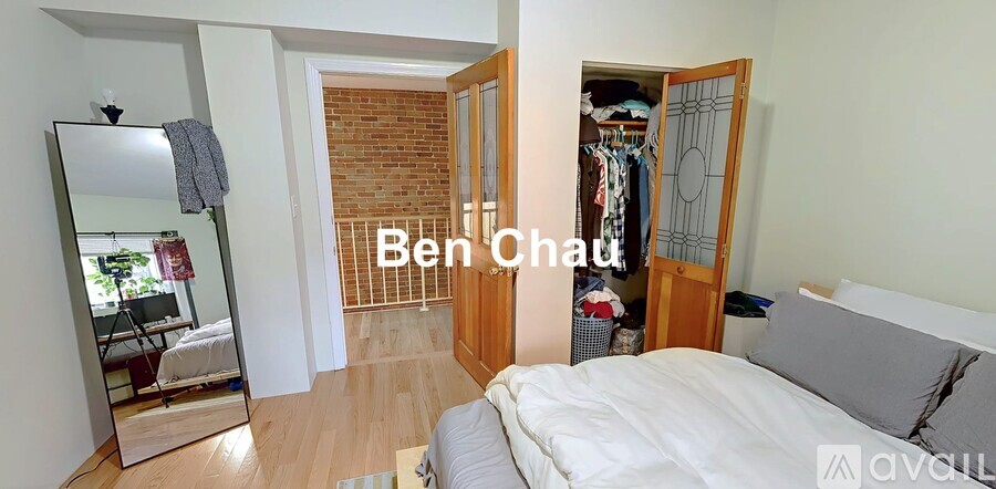 A bedroom with a bed, wardrobe and a mirror.