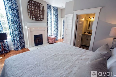 A bedroom with a large bed and a fireplace.