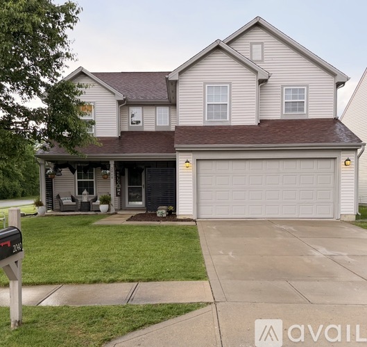 A two-story house with a garage and a driveway.