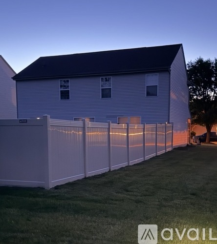 A white house with a fence in front of it.