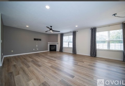 A spacious room with wood flooring and a fireplace.