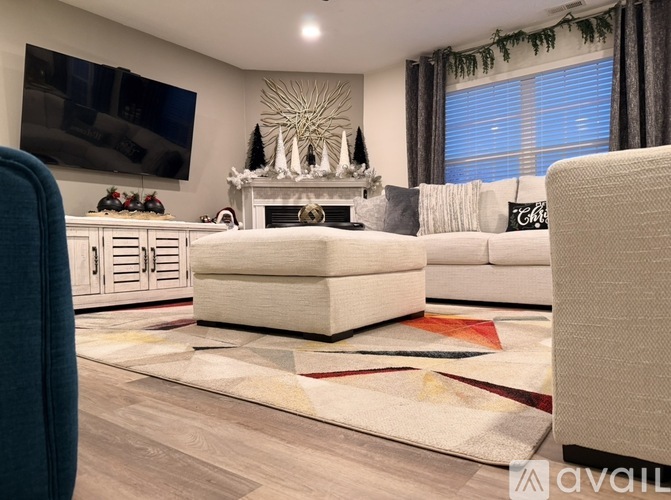 A living room with a fireplace and a large TV on the wall.