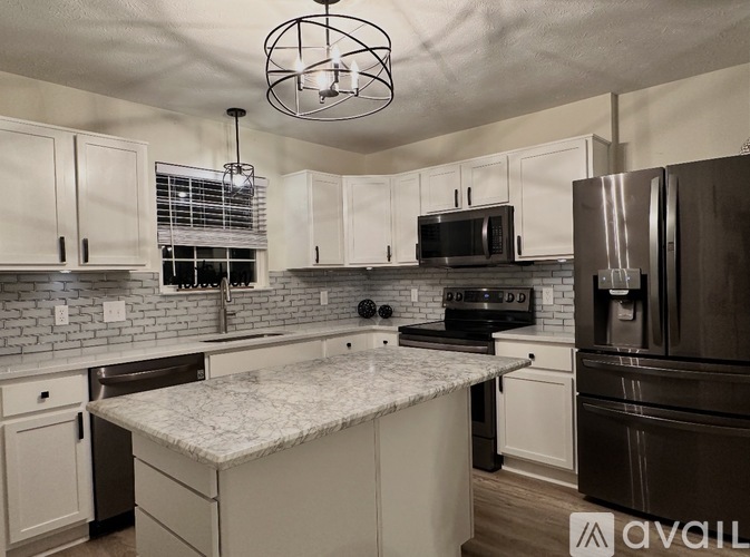 A kitchen with a marble countertop and stainless steel appliances.