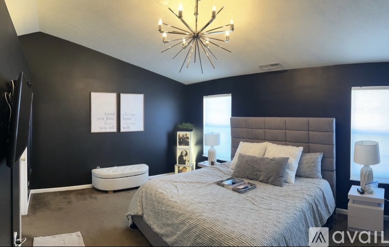 A bedroom with a large bed and a chandelier.