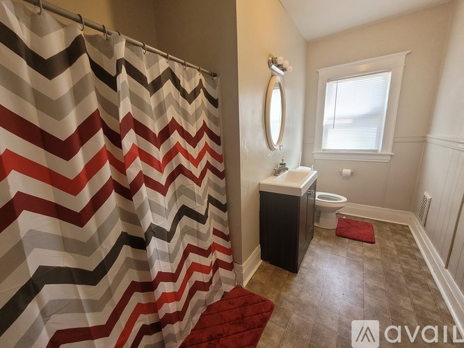 A bathroom with a shower curtain and a toilet.