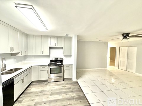 A kitchen with white cabinets and a black dishwasher.