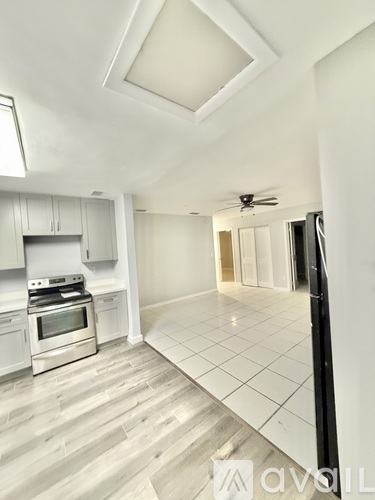 A kitchen with a refrigerator, oven, and cabinets.