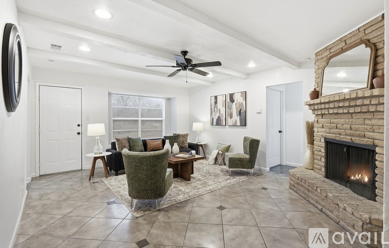 A living room with a fireplace and a ceiling fan.