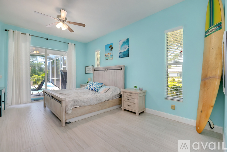 A bedroom with a bed, dresser, and surfboard.