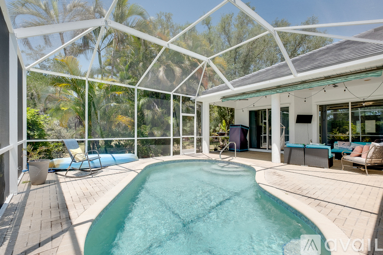 A pool inside a glass house with a white frame.