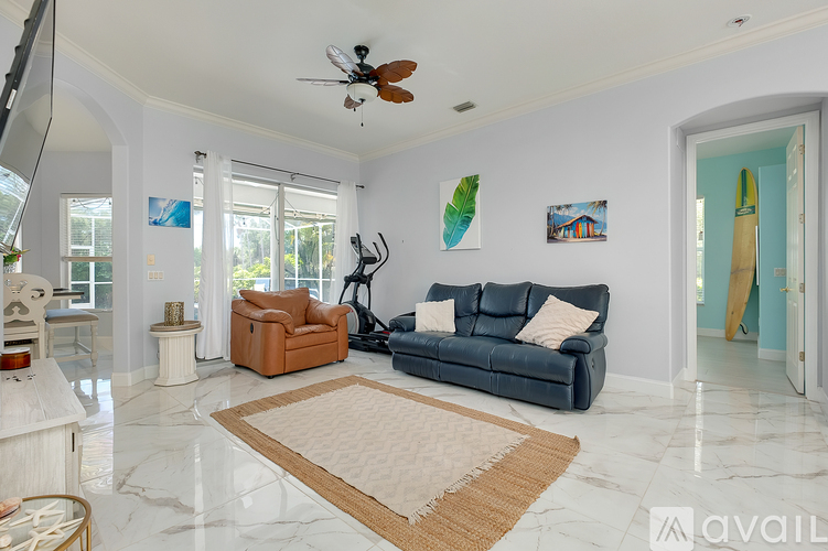 A living room with a blue couch and a rug in the middle.