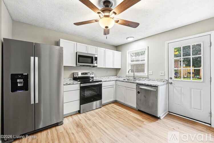 A kitchen with a refrigerator, microwave, oven, and stove.
