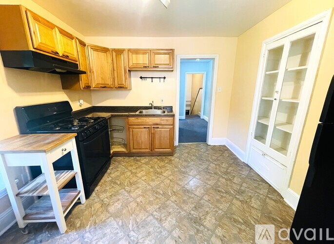 A kitchen with black appliances and wooden cabinets.