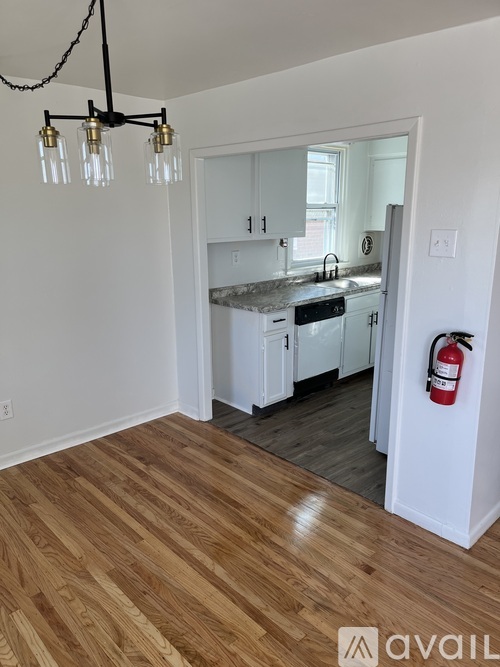 A kitchen with a wooden floor and a chandelier.