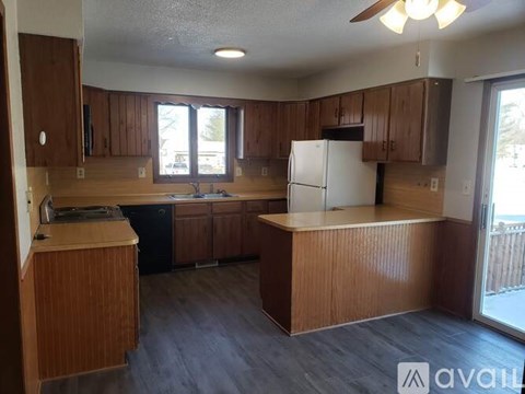 A kitchen with wooden cabinets and a white refrigerator.