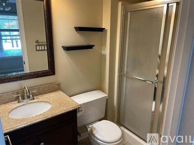 A bathroom with a toilet, sink, and shower.