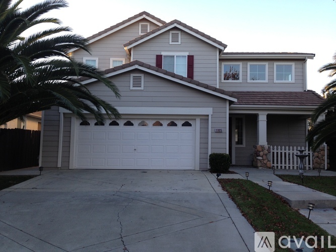 A two-story house with a garage and a driveway.