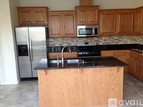 A kitchen with wooden cabinets and a black countertop.