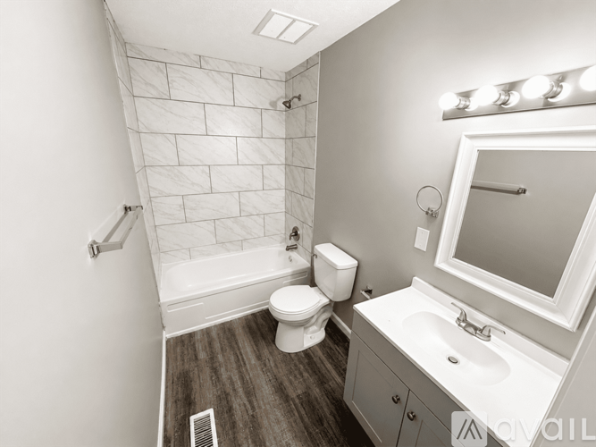 A bathroom with a toilet, sink, and mirror.