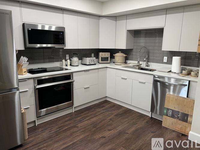 A kitchen with white cabinets and a wooden floor.
