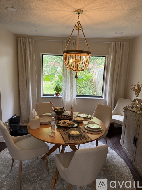 A dining room with a round table set for a meal.