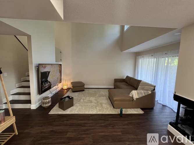 A living room with a couch, a chair, a rug, and a fireplace.