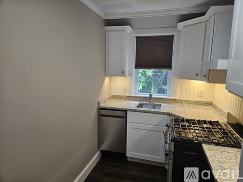 A kitchen with white cabinets and a granite countertop.