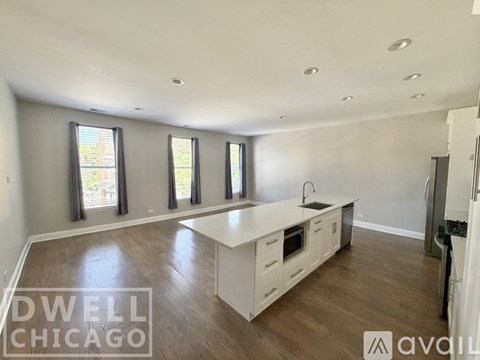 A spacious kitchen with white cabinets and a large island in the middle.