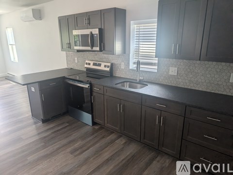 A kitchen with dark wood floors and cabinets.