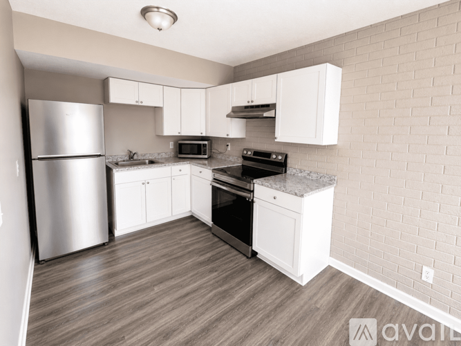 A kitchen with a refrigerator, oven, and microwave.