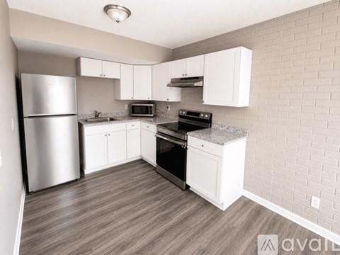 A kitchen with a refrigerator, oven, and microwave.