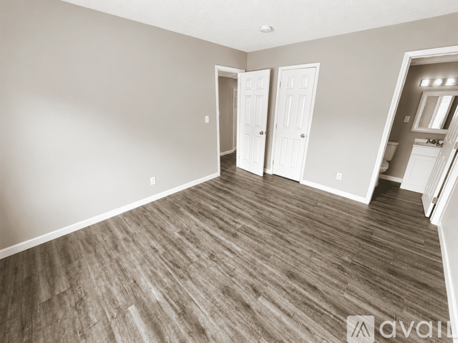 A room with wood flooring and two white doors.
