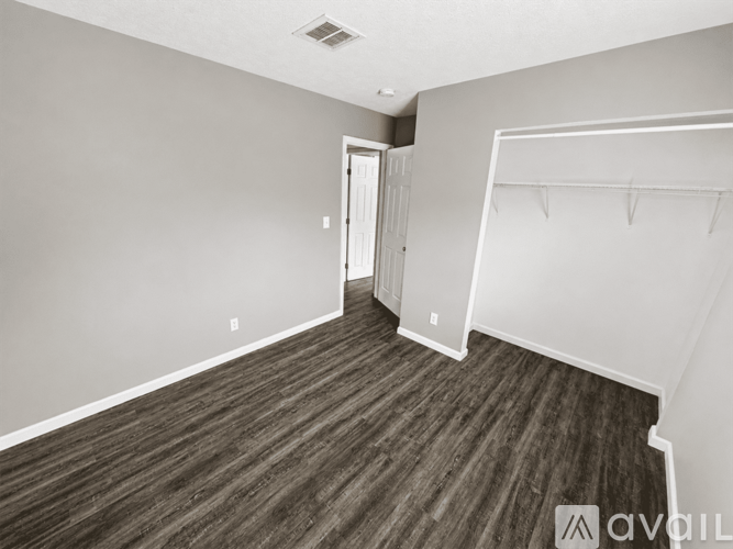 A room with a wooden floor and a white closet.