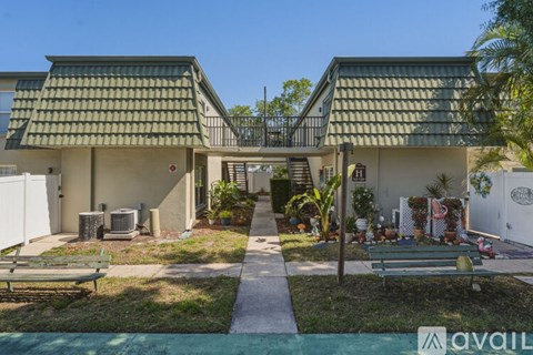 A house with a green roof and a white fence.
