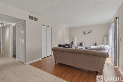 A living room with a couch and a bed in the background.