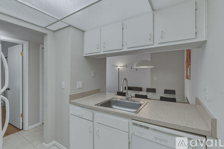 A kitchen with white cabinets and a sink.