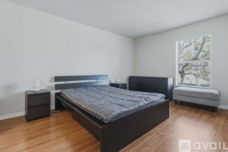 A bedroom with a large bed and a bench.