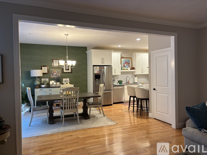 A modern kitchen with a dining table set up with chairs.